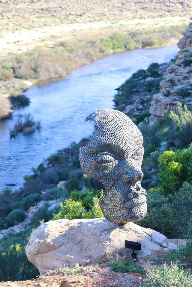 Detail of the wire-mesh face sculpture above the Doring River