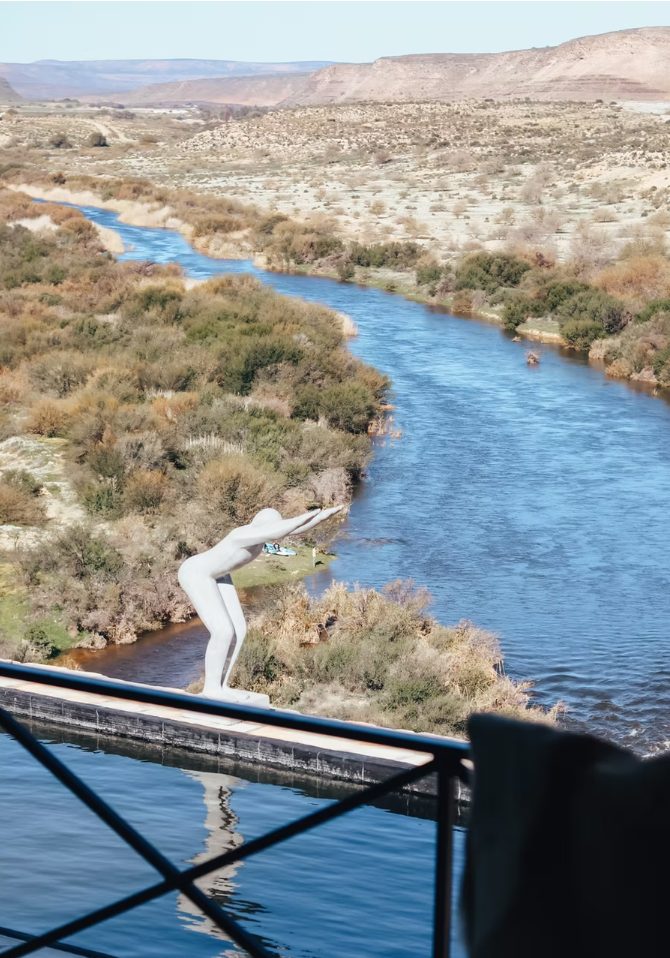 Sculpture of a diving figure above the Doring River